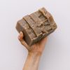 Holding five bars of handmade organic oatmeal cookie soap with exfoliating oatmeal and clove essential oil