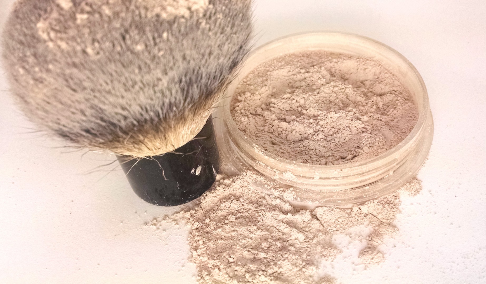 a kabuki brush next to custom loose mineral foundation enriched with skin-loving ingredients and Titanium Dioxide/Zinc Oxide for sun protection