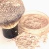Custom-matched mineral foundation in a sleek jar with powder spilling elegantly.