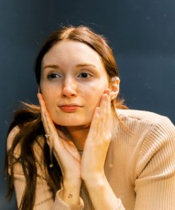 A serene, fresh-faced model with radiant skin after using the cleanser.