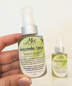 holding a bottle of Immortelle Facial Serum Vitamin C facial oil with Cranberry seed oil for deep hydration as a serum for radiant skin containing Antioxidant rich Oils and essential oils it is Plant-based skincare