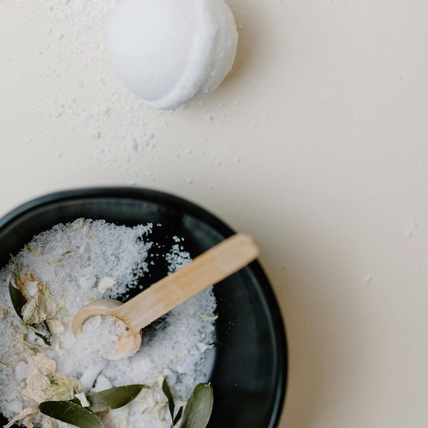 making a bath bomb with all the ingredients in a beautiful bowl to describe a bath bomb making class in Superior, WI