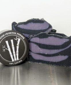 handmade, organic soap with activated charcoal powder to cleanse pores and detoxify skin, two bars of soap with container of activated charcoal, soap has purple and black swirls, scented with essential oils of lavender, bay and clove