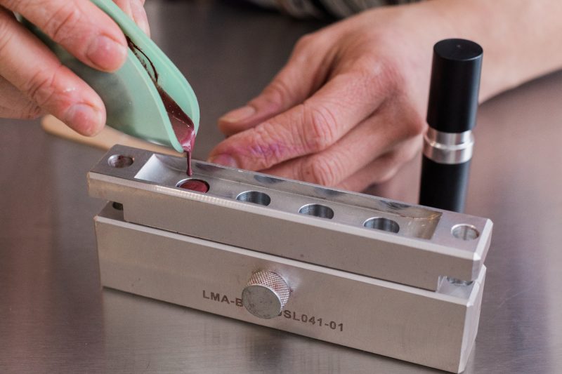 pouring custom lipstick into the mold at Mix Cosmetiques where personalized cosmetics are made
