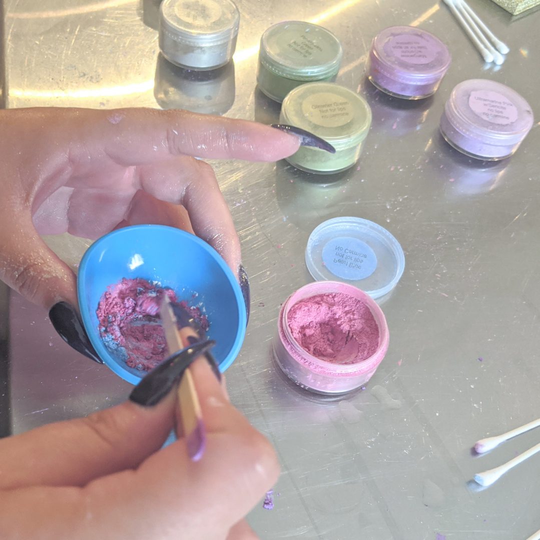 choosing pigments and mixing colors at an eyeshadow making workshop for a four color palette