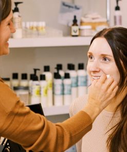 mixologist applying custom tinted everything cream to a model wanting to try custom makeup