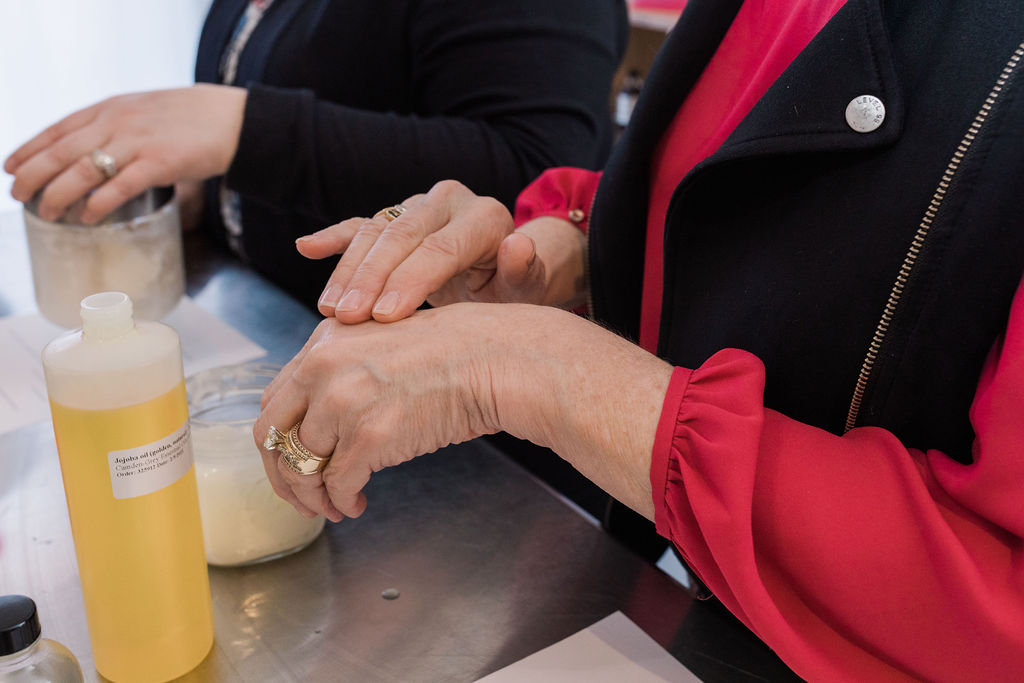 using plant based ingredients and oils on back of hand to choose which oil is best for skin at a workshop when looking for things to do in duluth and superior
