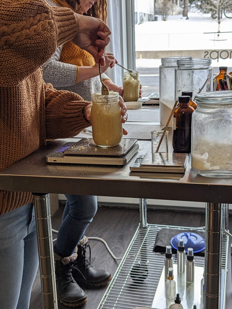 workshop participants stirring their make and take your own sugar scrub body polish at clean stainless tables using all natural organic ingredients and scented with essential oils when you find things to do in duluth superior on a cold rainy day
