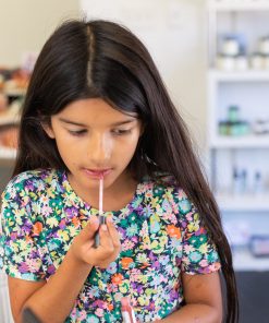 young teen girl applying hydrating lip gloss with natural ingredients, lip plumping hyaluronic acid and no micro-plastics or petroleum based ingredients to make lips look healthy and shiny