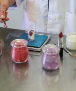 Mix Cosmetiques founder handcrafting organic custom lipstick with a customer, creating a personalized shade using natural, clean ingredients.